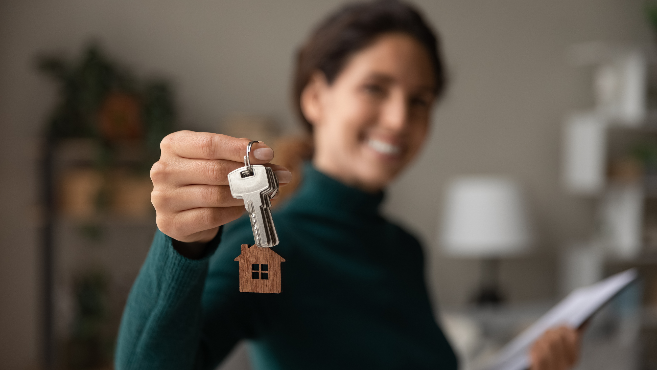 A woman holding keys with a house keychain